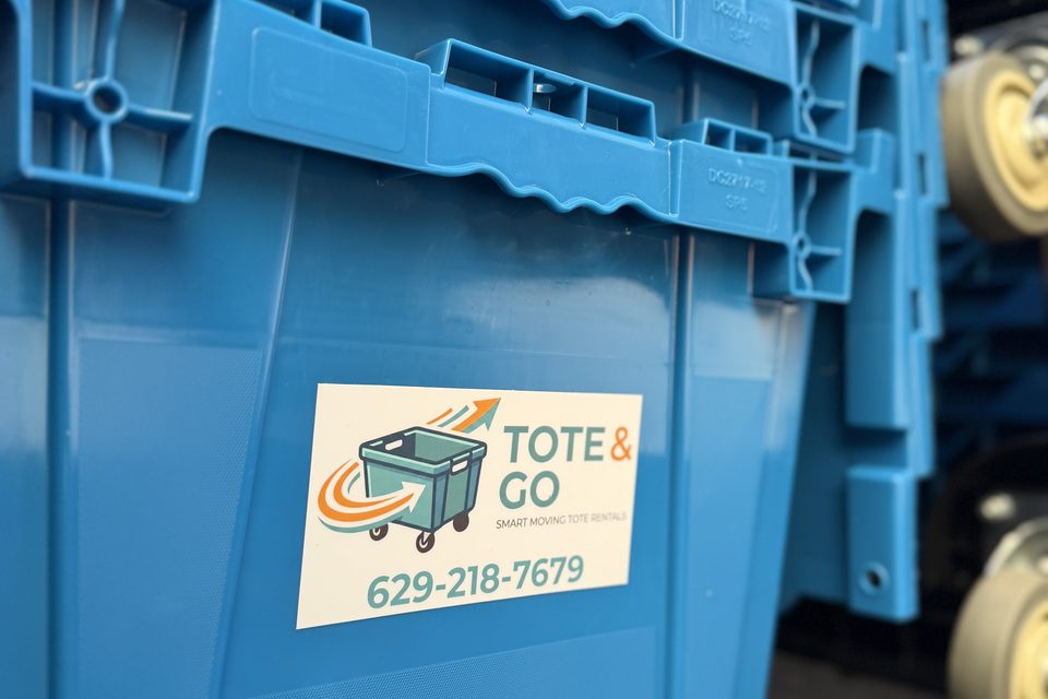 Tote & Go branded blue moving totes stacked on a dolly